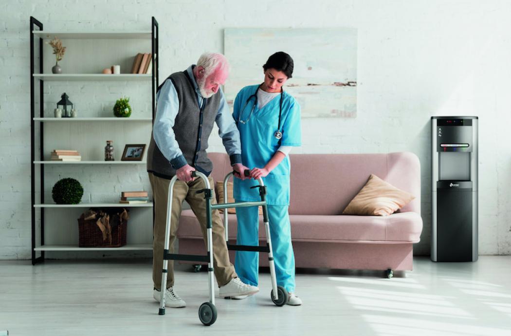 enfermera ayudando a un anciano, dispenser wl100 al fondo